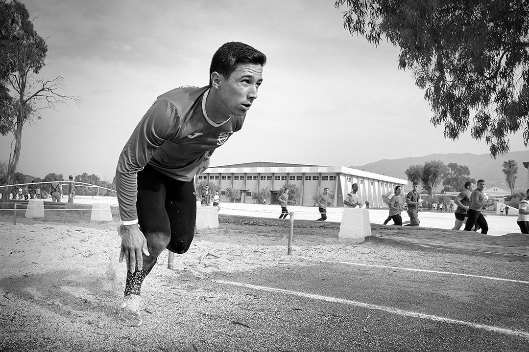 A runner leaning forwards on a sports track.